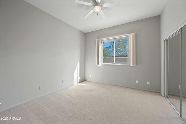 unfurnished bedroom featuring light colored carpet, a closet, and ceiling fan