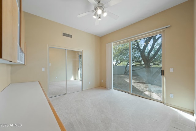 unfurnished bedroom with light carpet, access to outside, ceiling fan, and a closet