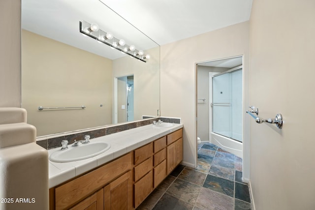 full bathroom with vanity, enclosed tub / shower combo, and toilet