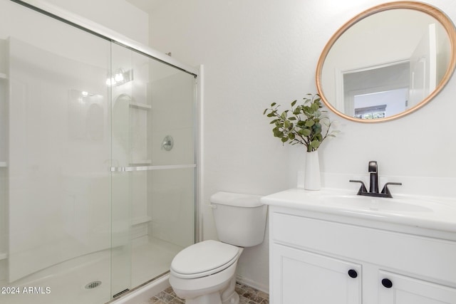 bathroom featuring vanity, toilet, and a shower with door