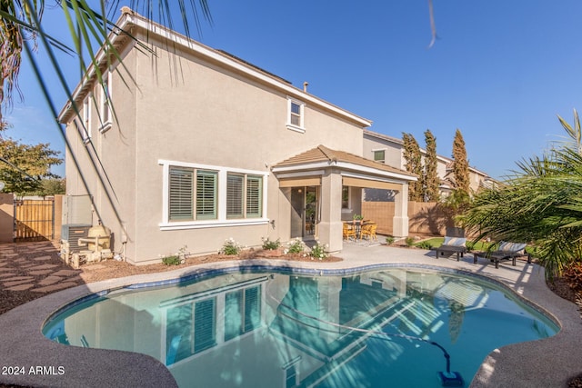 back of house featuring a patio and a fenced in pool