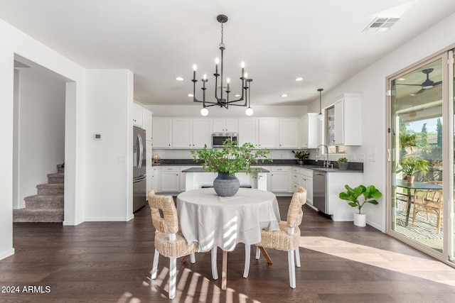 dining space with dark hardwood / wood-style flooring, sink, and a chandelier