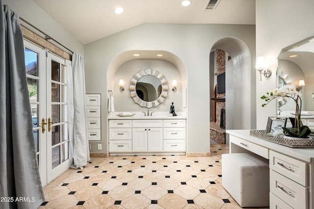 bathroom with lofted ceiling, french doors, and vanity