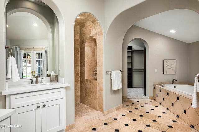 bathroom featuring vanity, french doors, and plus walk in shower