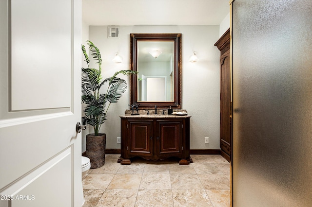 bathroom featuring toilet, a shower with door, and vanity