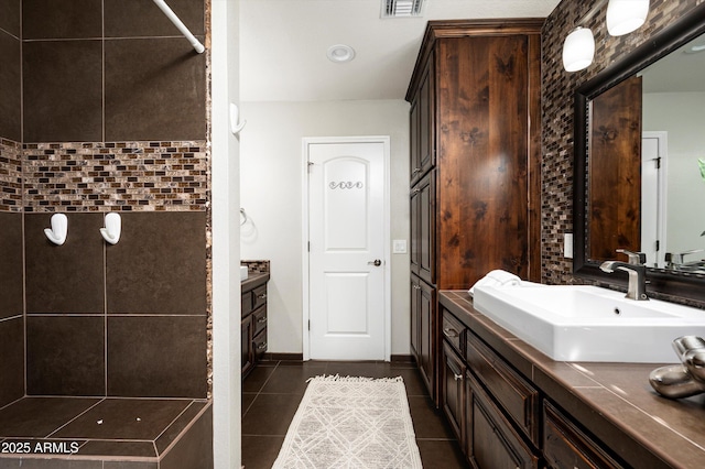 bathroom with tile patterned flooring, a shower, and vanity