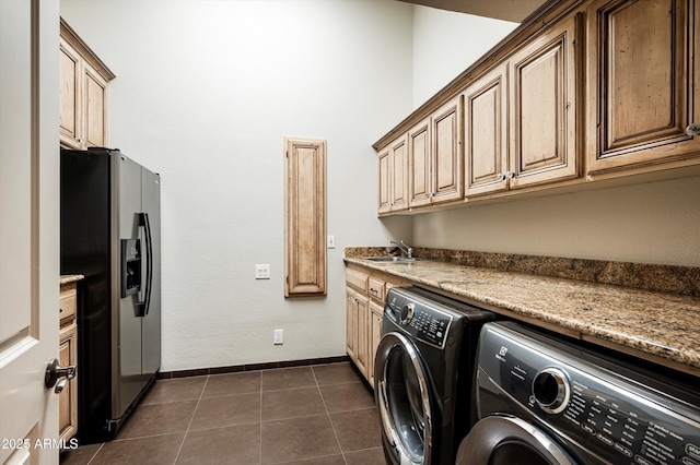 washroom featuring cabinets, washer and clothes dryer, dark tile patterned floors, and sink