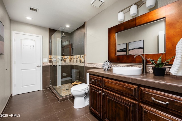 bathroom with toilet, vanity, tile patterned flooring, and a shower with shower door