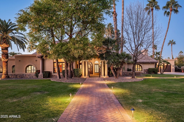 mediterranean / spanish-style home with a front lawn