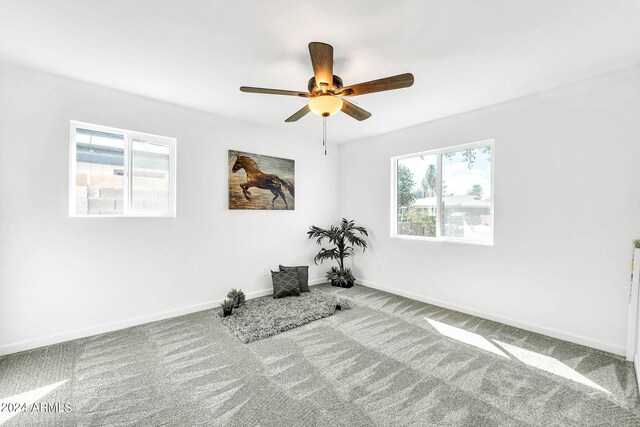 unfurnished room featuring carpet floors, a healthy amount of sunlight, and ceiling fan