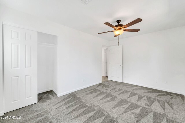 unfurnished bedroom featuring a closet, carpet, and ceiling fan