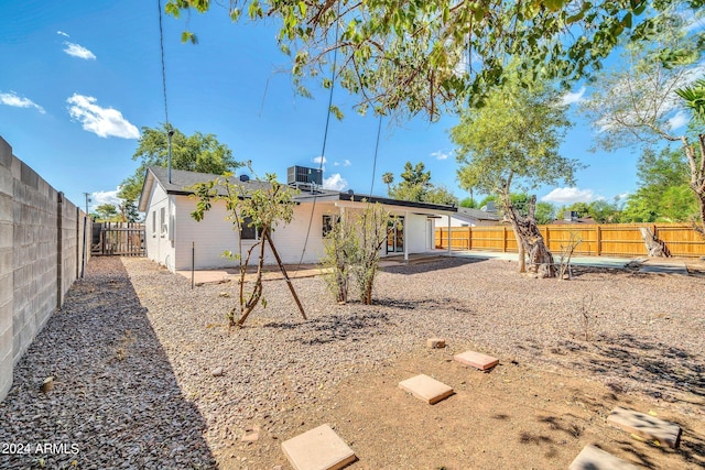 rear view of house with central AC unit and a patio area