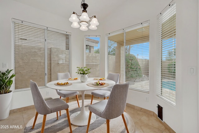 dining room featuring light tile patterned floors, a wealth of natural light, and an inviting chandelier