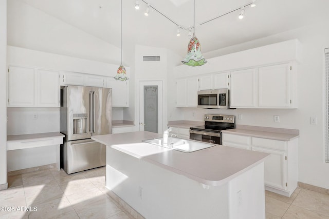 kitchen featuring pendant lighting, white cabinets, appliances with stainless steel finishes, a kitchen island with sink, and vaulted ceiling