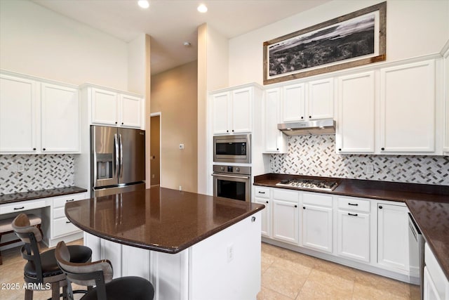 kitchen featuring stainless steel appliances, white cabinets, and decorative backsplash