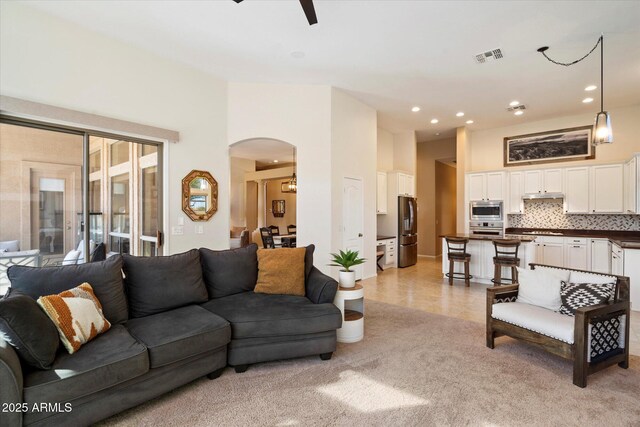 carpeted living room with ceiling fan