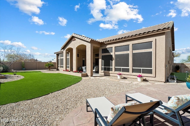 rear view of property featuring a patio and a lawn