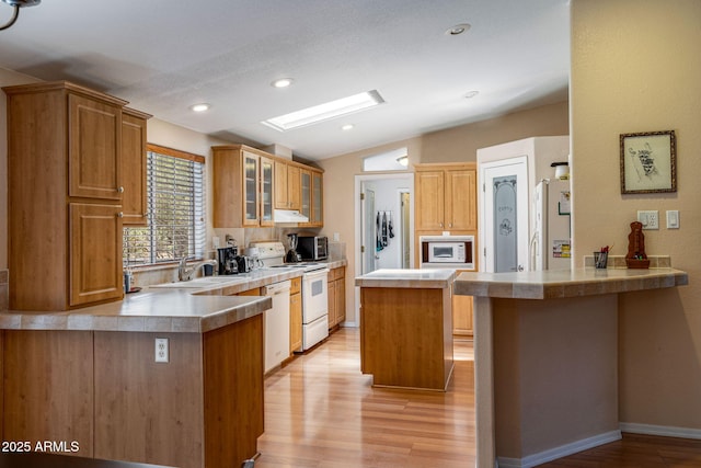 2041 W Hacienda Way, Show Low, AZ 85901 - kitchen with white appliances, a peninsula, light wood-type flooring, a sink, and vaulted ceiling