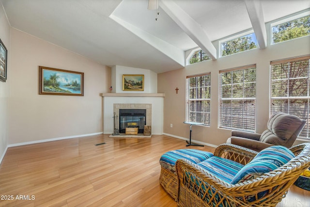 2041 W Hacienda Way, Show Low, AZ 85901 - living room featuring vaulted ceiling, a tiled fireplace, ceiling fan, light wood finished floors, and baseboards
