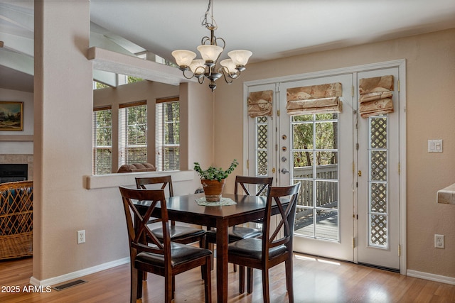 2041 W Hacienda Way, Show Low, AZ 85901 - dining space with wood finished floors, a chandelier, baseboards, and a glass covered fireplace