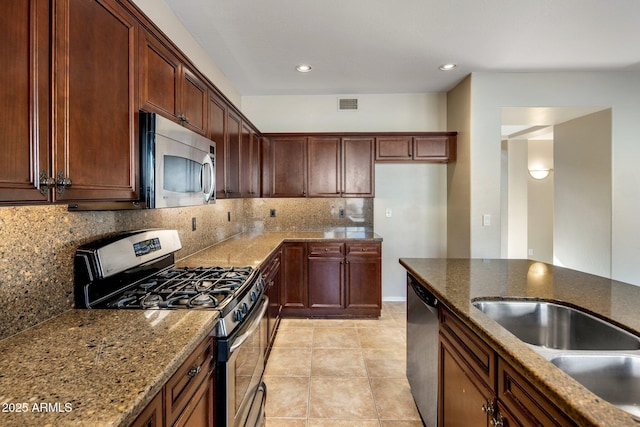 kitchen featuring sink, light tile patterned floors, appliances with stainless steel finishes, light stone countertops, and decorative backsplash