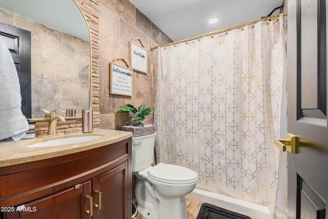 bathroom featuring hardwood / wood-style floors, vanity, toilet, tile walls, and curtained shower