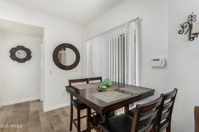 dining area with baseboards and light wood finished floors