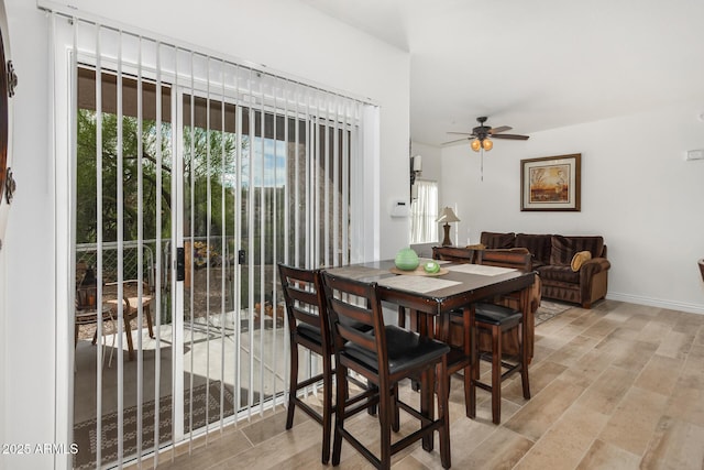 dining room featuring baseboards, ceiling fan, and light wood finished floors