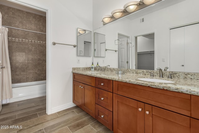 full bathroom featuring double vanity, shower / tub combo, wood tiled floor, and a sink