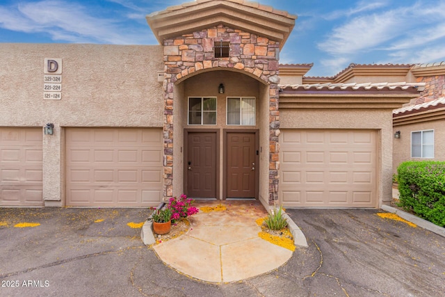 view of front of house featuring stucco siding, driveway, and a garage