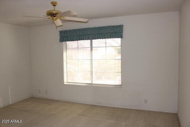 carpeted empty room featuring ceiling fan and a wealth of natural light