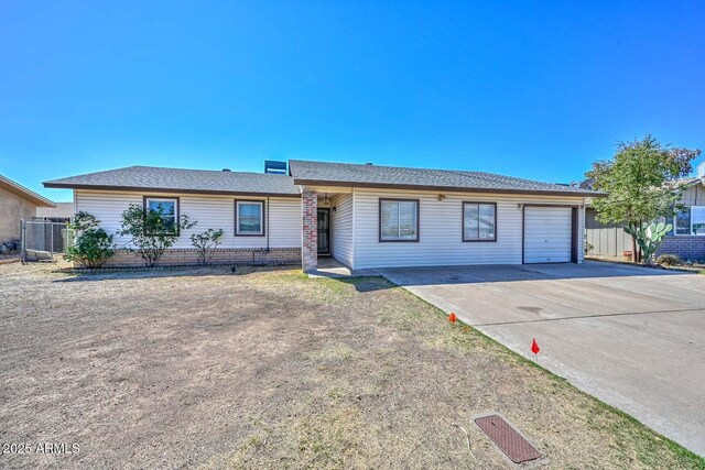ranch-style house with a garage, brick siding, fence, and concrete driveway
