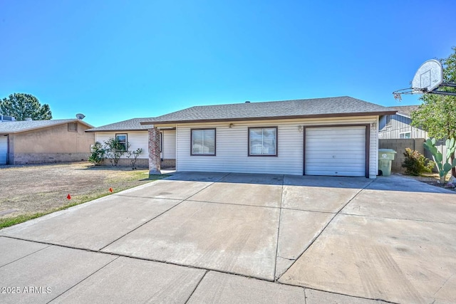 ranch-style house with fence, concrete driveway, and an attached garage
