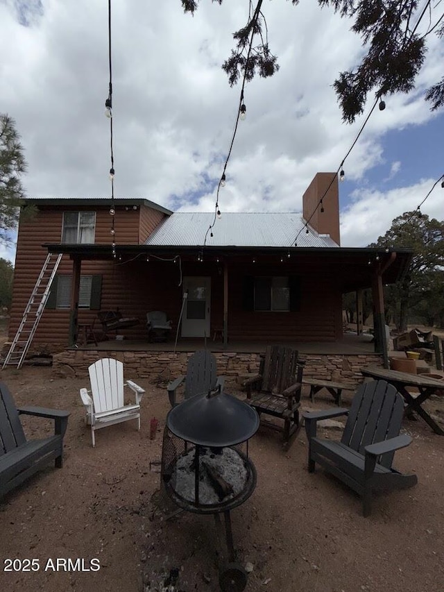 691 N Pyle Ranch Rd, Payson, AZ 85541 - back of property featuring an outdoor fire pit, a patio, log veneer siding, and metal roof