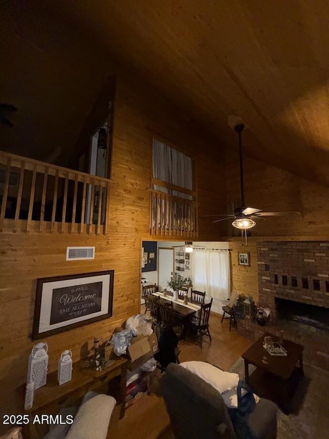 691 N Pyle Ranch Rd, Payson, AZ 85541 - living area featuring ceiling fan, high vaulted ceiling, wood finished floors, a fireplace with raised hearth, and wood walls