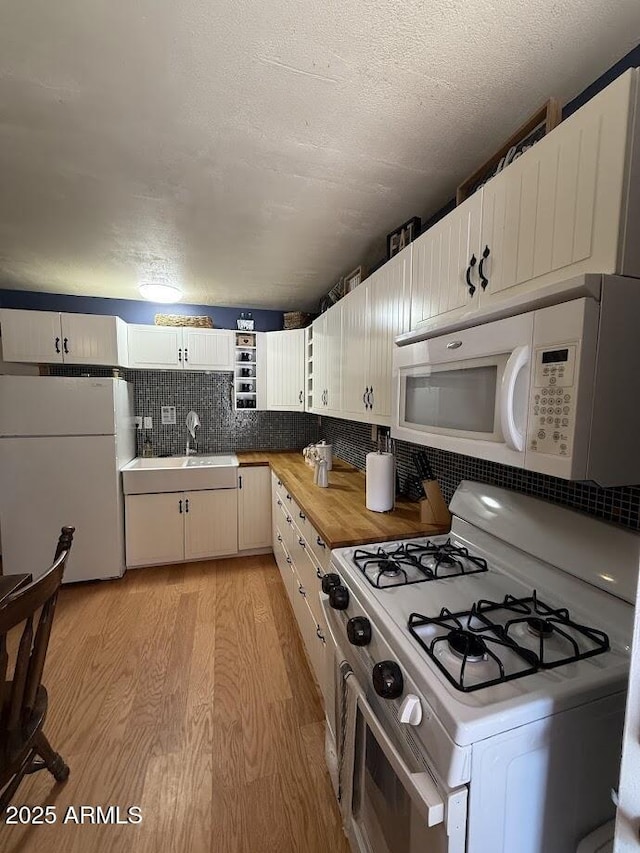 691 N Pyle Ranch Rd, Payson, AZ 85541 - kitchen with white appliances, light wood-style floors, a sink, butcher block countertops, and decorative backsplash