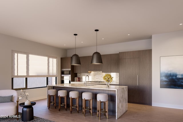 19360 N 73rd St Unit 1070, Scottsdale, AZ 85255 - kitchen featuring modern cabinets, tasteful backsplash, double oven, an island with sink, and a kitchen breakfast bar