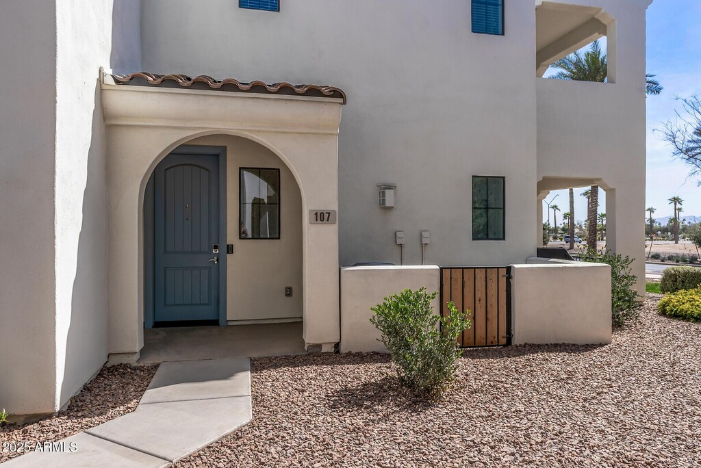 doorway to property with a tile roof and stucco siding