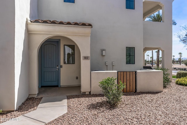 doorway to property with a tile roof and stucco siding