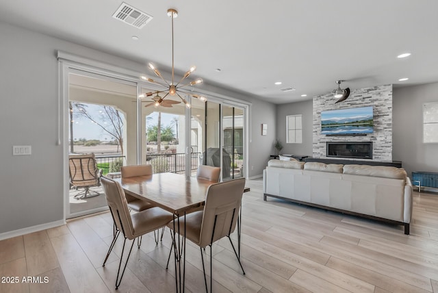 dining area with recessed lighting, a large fireplace, visible vents, baseboards, and light wood-type flooring