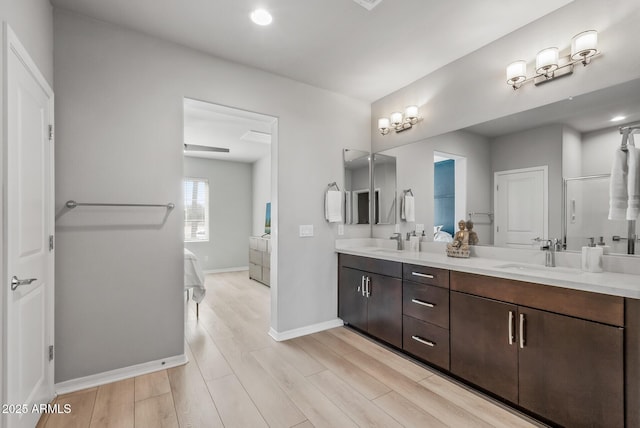 bathroom with double vanity, a sink, and wood finished floors