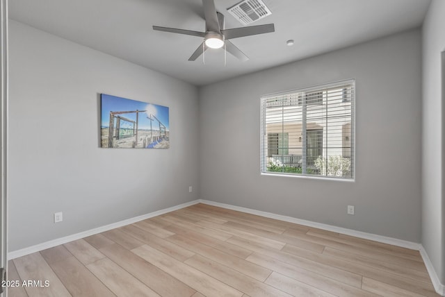 empty room featuring light wood-type flooring, visible vents, ceiling fan, and baseboards