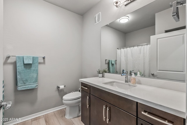 full bath with baseboards, visible vents, toilet, wood finished floors, and vanity