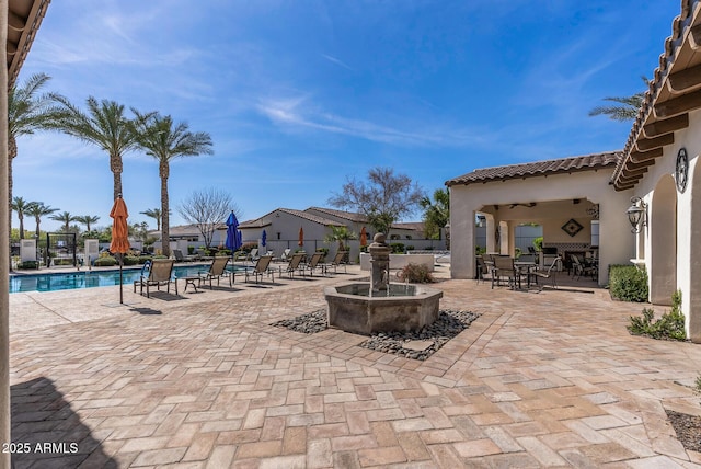 view of patio / terrace featuring a community pool and fence