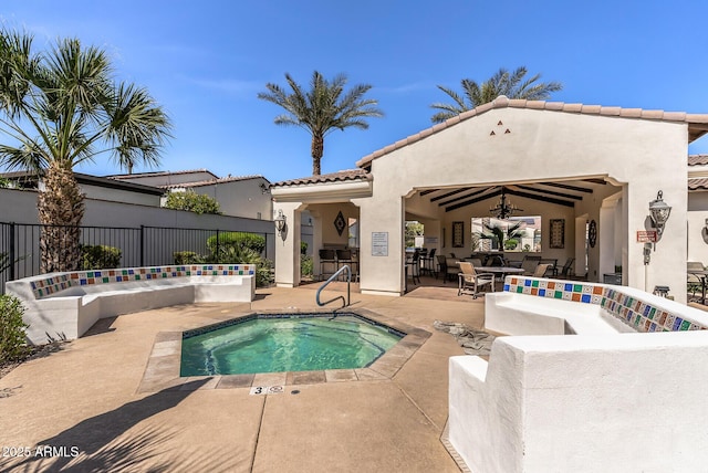 view of swimming pool featuring a hot tub, fence, and a patio