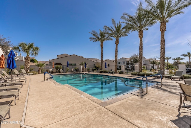 community pool with a residential view, a patio, and fence