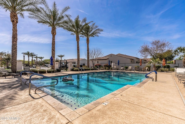 community pool featuring a patio area and fence