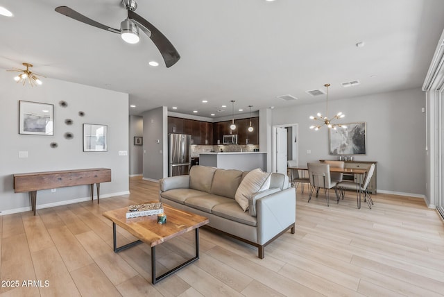 living room featuring light wood-type flooring, visible vents, and recessed lighting