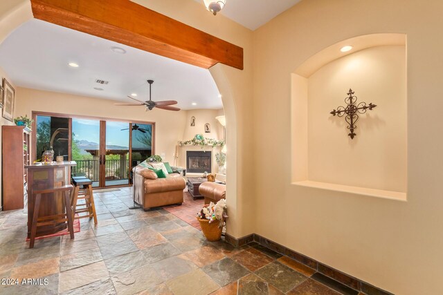 living room with ceiling fan and beam ceiling