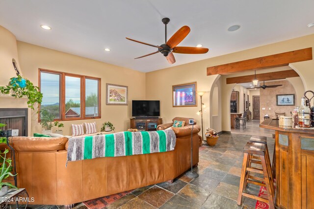 bar featuring beamed ceiling and ceiling fan